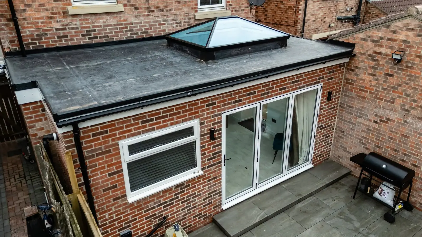 Flat-roof extension with lanterns and bifold doors from above, Shiremoor